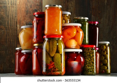 Jars with pickled vegetables, fruity compotes and jams in cellar. Preserved food