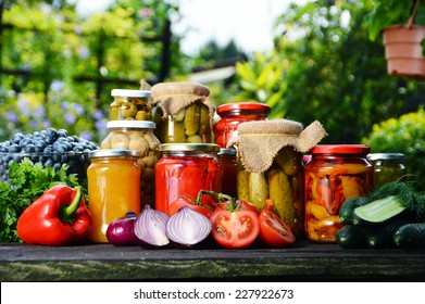 Jars of pickled vegetables in the garden. Marinated food.