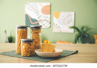 Jars And Plate With Uncooked Pasta On Kitchen Counter