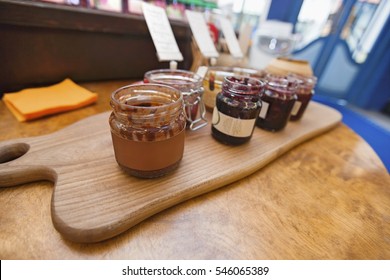 Jars Of Preserves On Cutting Board In Grocery Store