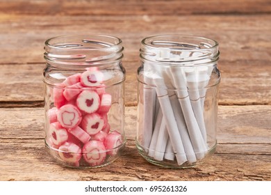 Jars With Sweets And Cigarettes. Make Your Choice: Sweet Candy Or Toxic Cigarettes.