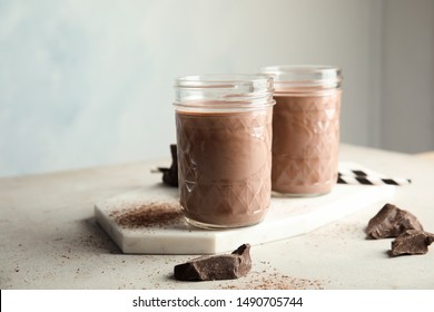 Jars With Tasty Chocolate Milk On Table. Dairy Drink