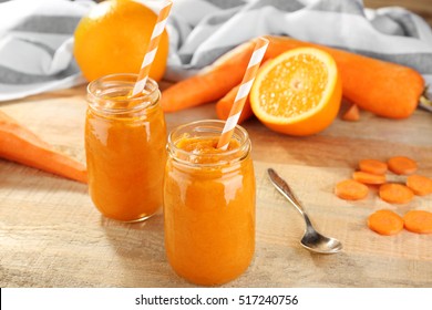 Jars with vegetable smoothie on wooden background