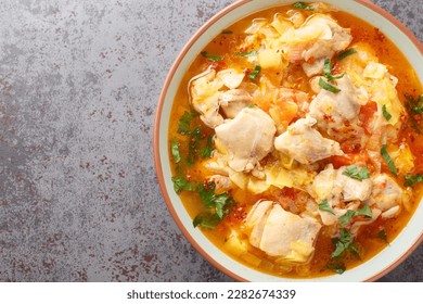 Jasha maroo is a traditional Bhutanese dish consisting of chicken that is cooked with garlic, ginger, chiles, leek and tomato sauce closeup on the bowl on the table. Horizontal top view from above - Shutterstock ID 2282674339