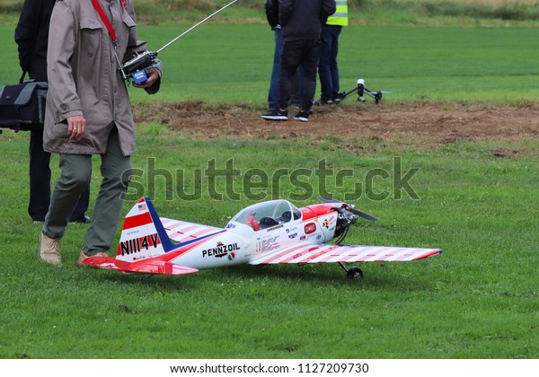Jaslo, Poland - july 1 2018:A man is a\
participant with a radio-controlled airplane model on the grassy\
aerodrome runway. Exhibition, competitions and airshow. Hobbies and\
free time. Miniatures.