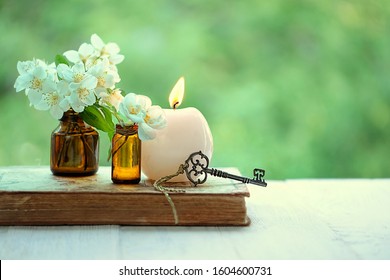 jasmine flowers, vintage key, candle, old book. spring or summer image. romantic spa relax still life. copy space