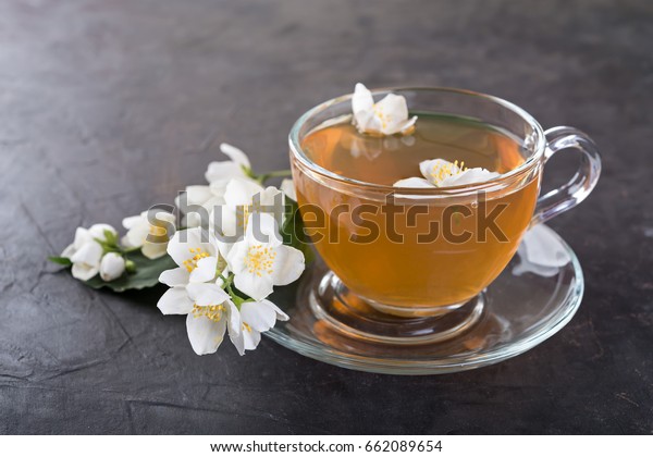 Jasmine\
tea with jasmine flowers on a dark \
background\
