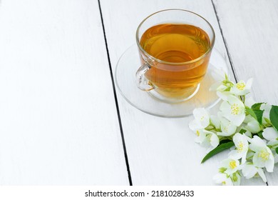 Jasmine tea in glass cup and flowers on a wooden white background. Cup with green jasmin tea. Tea time - Powered by Shutterstock