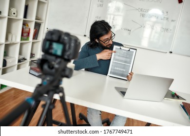 Javascript online. Young man teaching explaining java basics while working online from home. Recording video tutorial. Focus on a teacher. E-learning. Distance education. Blogging, vlogging