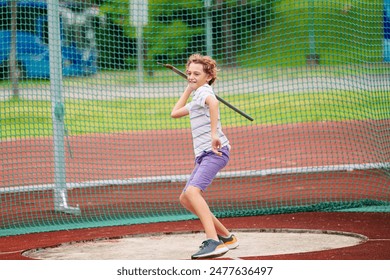 Javelin throw competition for kids. Athletics club training in school. Little boy throwing javelin on school stadium. Young athlete exercising. Healthy sport outdoor. - Powered by Shutterstock