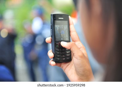 Jayapura, Indonesia - 13 February 2021: a young man records a female artist using a cellphone during a party celebration