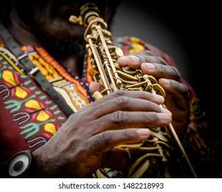 A Jazz Musician Wearing Bright Clothes Playing A Soprano Sax.