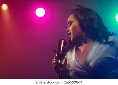 A jazz singer performs on stage. Afro.