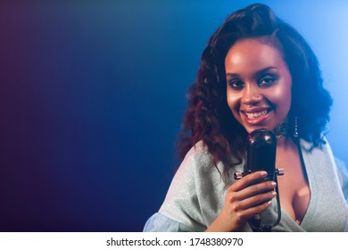 A jazz singer performs on stage. Afro.