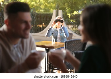 Jealous ex girlfriend spying on couple in outdoor cafe