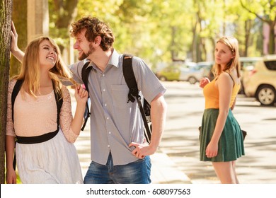 Jealous girl looking at flirting couple outdoor. Happy young woman and man couple dating. Summer romance affair.
