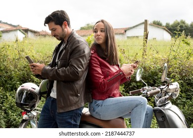 Jealous Girlfriend Spying On Her Boyfriend's Smartphone While He Is Smiling. Woman Looks At The Man's Cell Phone While She Suspects Infidelity. Couple Spying On Her Husband's Privacy And Trust