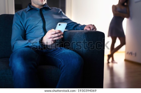 Jealous woman and cheating man with a phone.\
Infidelity, jealousy and betrayal. Cheater husband texting with\
mistress and secret lover. Suspicious wife peeking and spying.\
Unfaithful sneaky\
boyfriend.