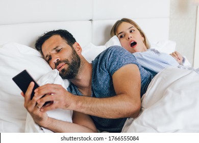 Jealous woman spying her partner's phone while he is reading a message