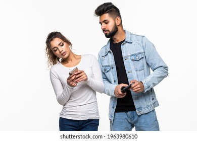 Jealous Young Woman Peeking At The Mobile Phone Of Her Boyfriend Isolated On White Background