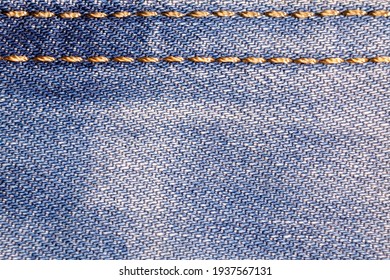 Jeans background. Denim fabric with seams close-up.