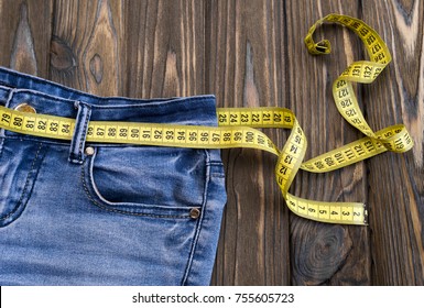 Jeans, Centimeter On A Wooden Background. Diet. Waist