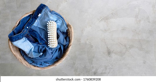 Jeans In Laundry Basket On Cement Floor Background. Top View