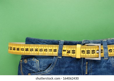 jeans with meter belt slimming on the green background - Shutterstock ID 164062430