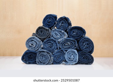 Jeans rolled up stacked in pyramid on a wooden background - Powered by Shutterstock