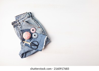 Jeans shorts with tools to repair old clothes. Slow fashion, circular economy, eco friendly sustainable shopping, thrifting second hand shop concept.