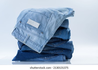 Jeans trousers stack on white background in supermarket and store. business jeans concept. - Shutterstock ID 2130131375