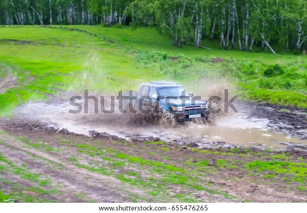 Jeep car rides in the mud with splashes. Russia,\
Tyumen. June 2014