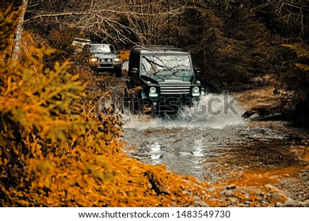 Jeep crashed into a puddle and picked up a spray of dirt. Mud and water splash in off-road racing. Off the road travel on mountain road. Track on mud. 4x4 Off-road suv car. Offroad car. Safari