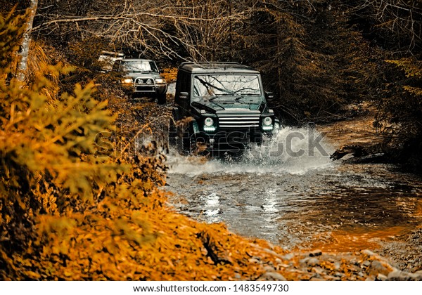 Jeep crashed into a puddle and picked up a spray\
of dirt. Mud and water splash in off-road racing. Off the road\
travel on mountain road. Track on mud. 4x4 Off-road suv car.\
Offroad car. Safari