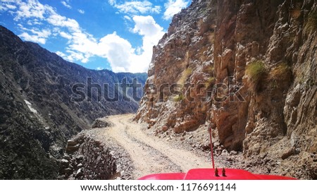 A Jeep Ride on the dangerous and serpentine road in a rock mountain to Fairy Meadows, Nanga Parbat, Karakorum, Northern Area Of Pakistan with background of blue sky and dramatic cloud