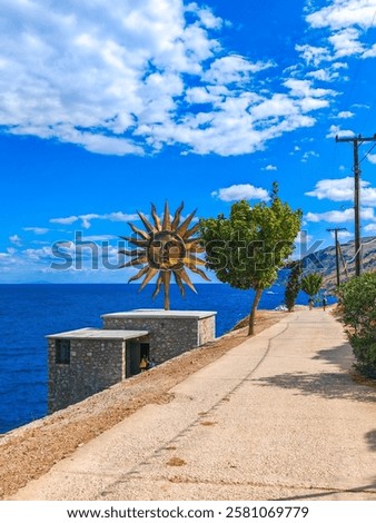 Jeff Koons’ Apollo sculpture on Hydra Island—a massive, golden, rotating sun-like disc atop the Slaughterhouse Project Space. Its reflective surface shines across the island.