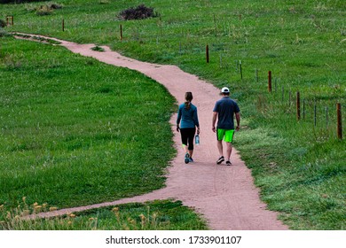 Jefferson County, Colorado,USA, 5/16/2020, two hikers on Coyote song  trail in South Valley Park, Jefferson County, Colorado, with green prairie grass