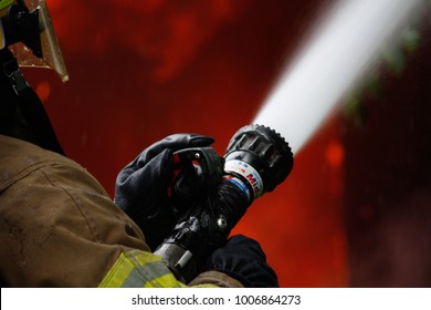 Jefferson, Oregon/USA - 05-05-2012   Close Up Of Fire Fighter And The Hose Spraying Water