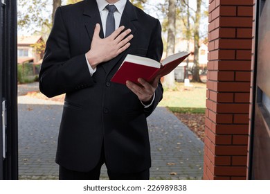 Jehovah's Witness Standing At The Door And Holding Bible