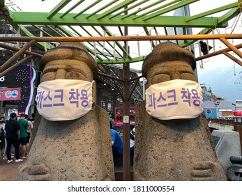 Jeju/South Korea - 1st July 2020: Two stone figures wearing masks. "WEAR MASK"