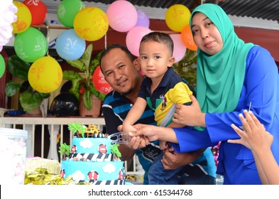 JELEBU,MALAYSIA - APRIL 1, 2017: Happy family celebrates son's 9th birthday at Negeri Sembilan, Malaysia. Cakes, candy and balloon is compulsory at birthday party   