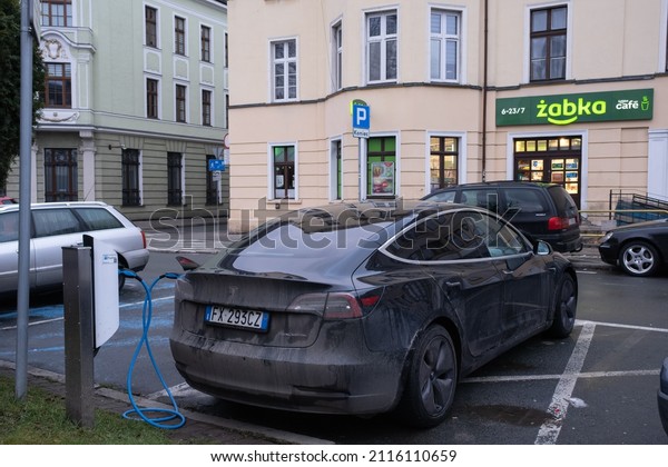 Jelenia Gora, Poland -\
January 15, 2022. A static shot of a solid black Tesla Model 3 dual\
motor charging at the AC charging station in a sunny winter day.\
Selective focus.