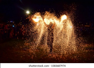 Jelgava, Latvia - 06.09.2019: A Man Spinning And Throwing A Lot Of Sparks At A Fire Show At The International Sand Sculpture Festival, In Summer, At Night