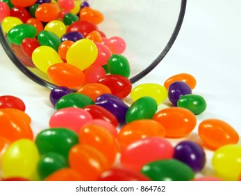 Jelly Beans Falling Out Of A Glass Jar Isolated On White.