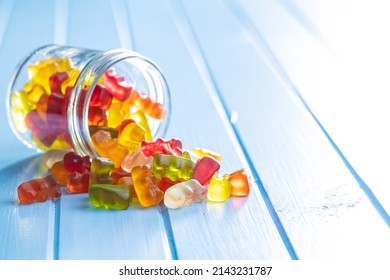 Jelly gummy bears candy. Colorful sweet confectionery on blue table. - Shutterstock ID 2143231787