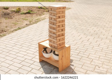 Jenga Puzzle Made Of Wooden Blocks. Outdoor Play, Entertainment. Tower Of Wood. Pastime In The Company.