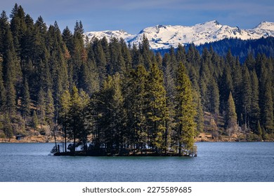 Jenkinson Lake in Sly Park and snow capped Sierra Nevada Mountains in the background in the Northern California in the winter