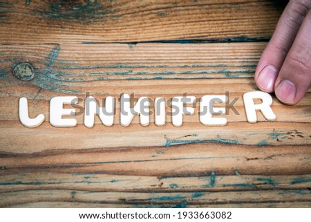 JENNIFER. Name of women and girls. White letters of the alphabet on a wooden background