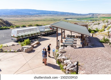 Jensen, USA - July 23, 2019: High Angle View Of Shuttle Bus Stop, Parking Lot By Quarry Visitor Center Exhibit Hall In Dinosaur National Monument Park With People, Utah