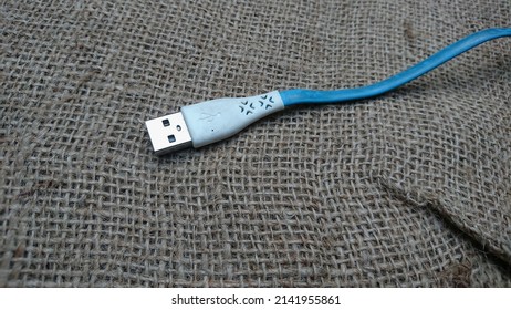 JEPARA, INDONESIA - APRIL 02 2022 : Mobile Phone USB Cable With Gunny Sack Texture Background